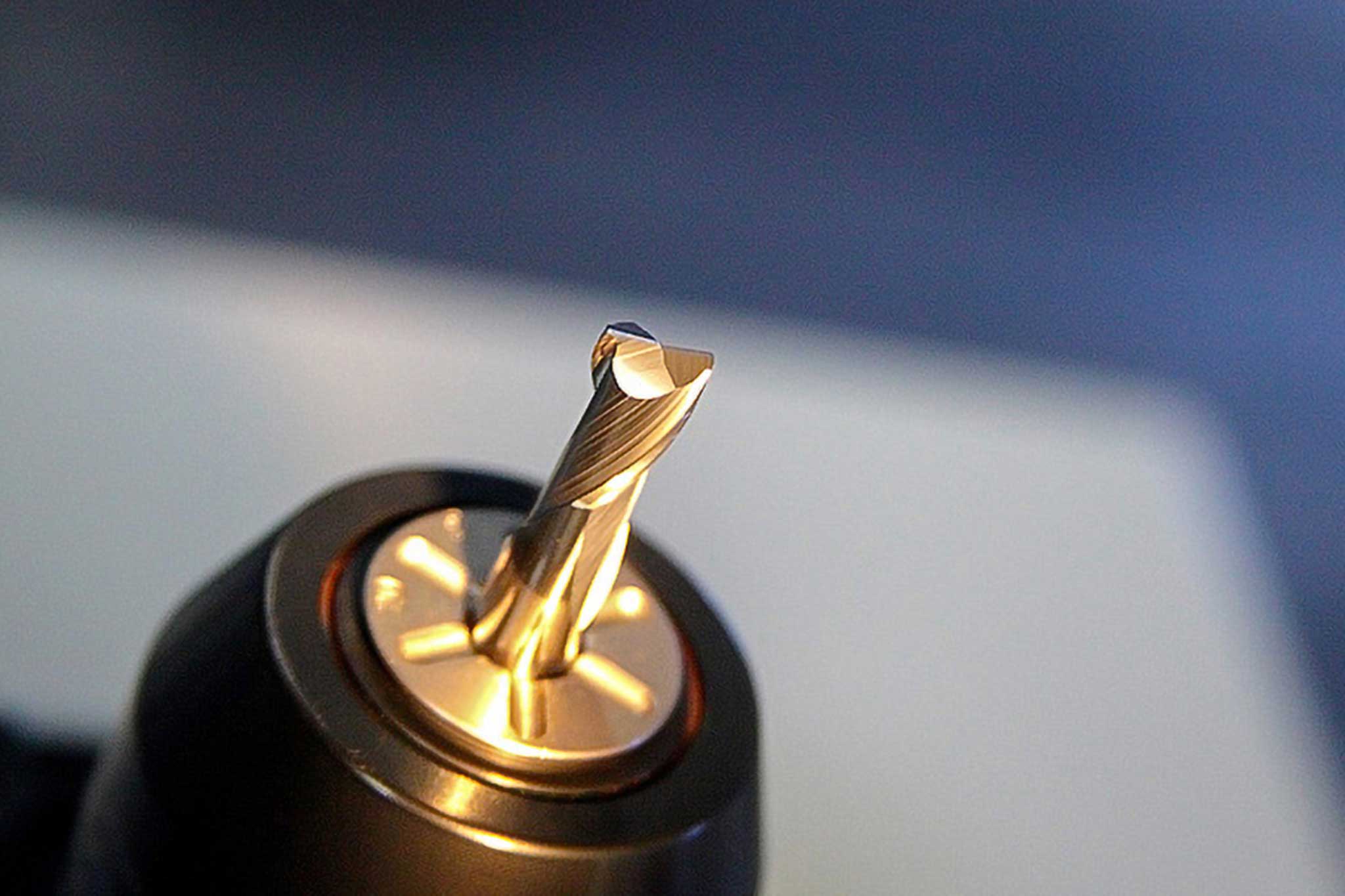 A golden milling tool from voha-tosec is shown in a chuck.