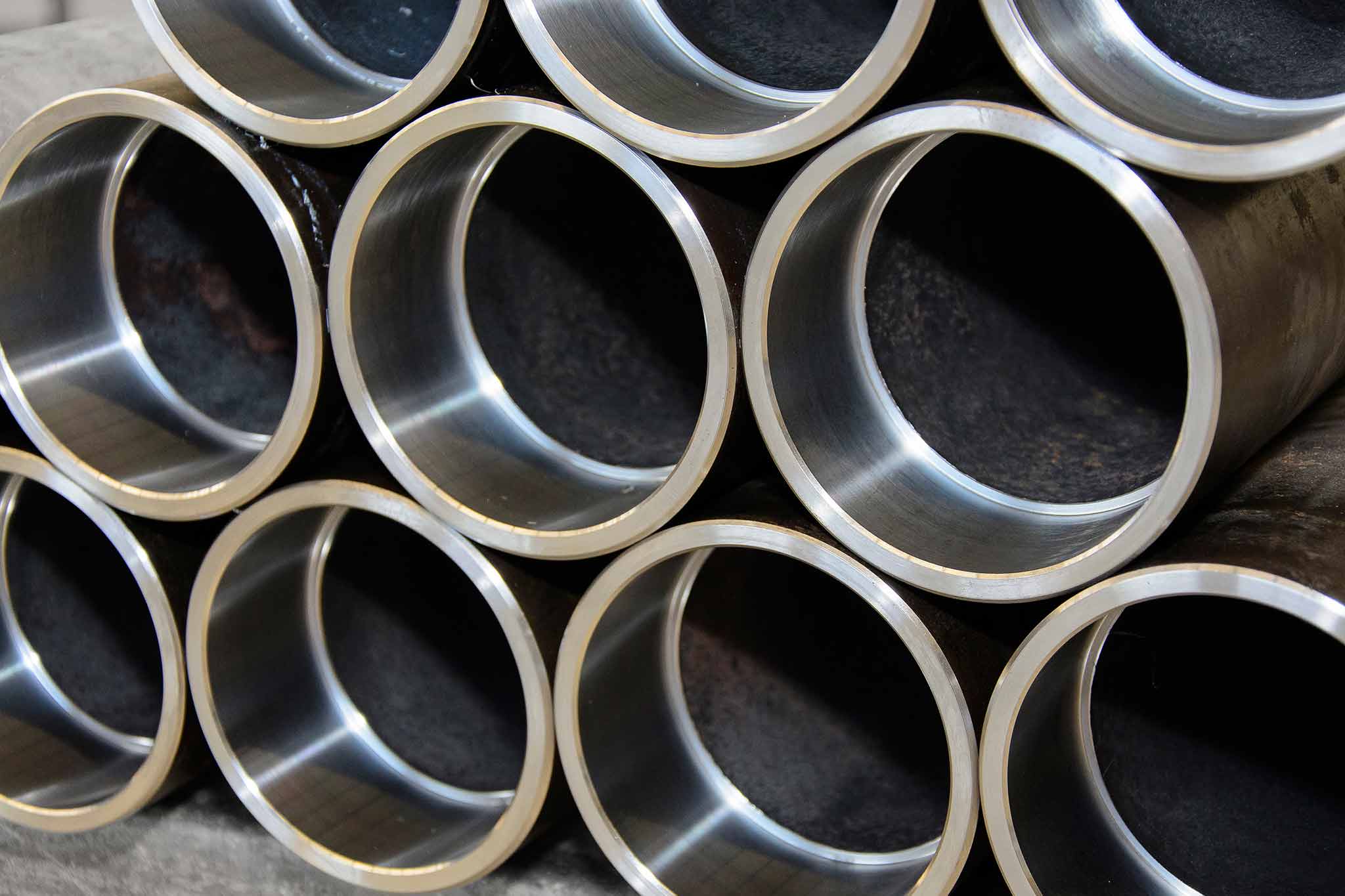 A total of ten pipe ends are shown in the image, some of them cut. They are stacked on top of each other. 