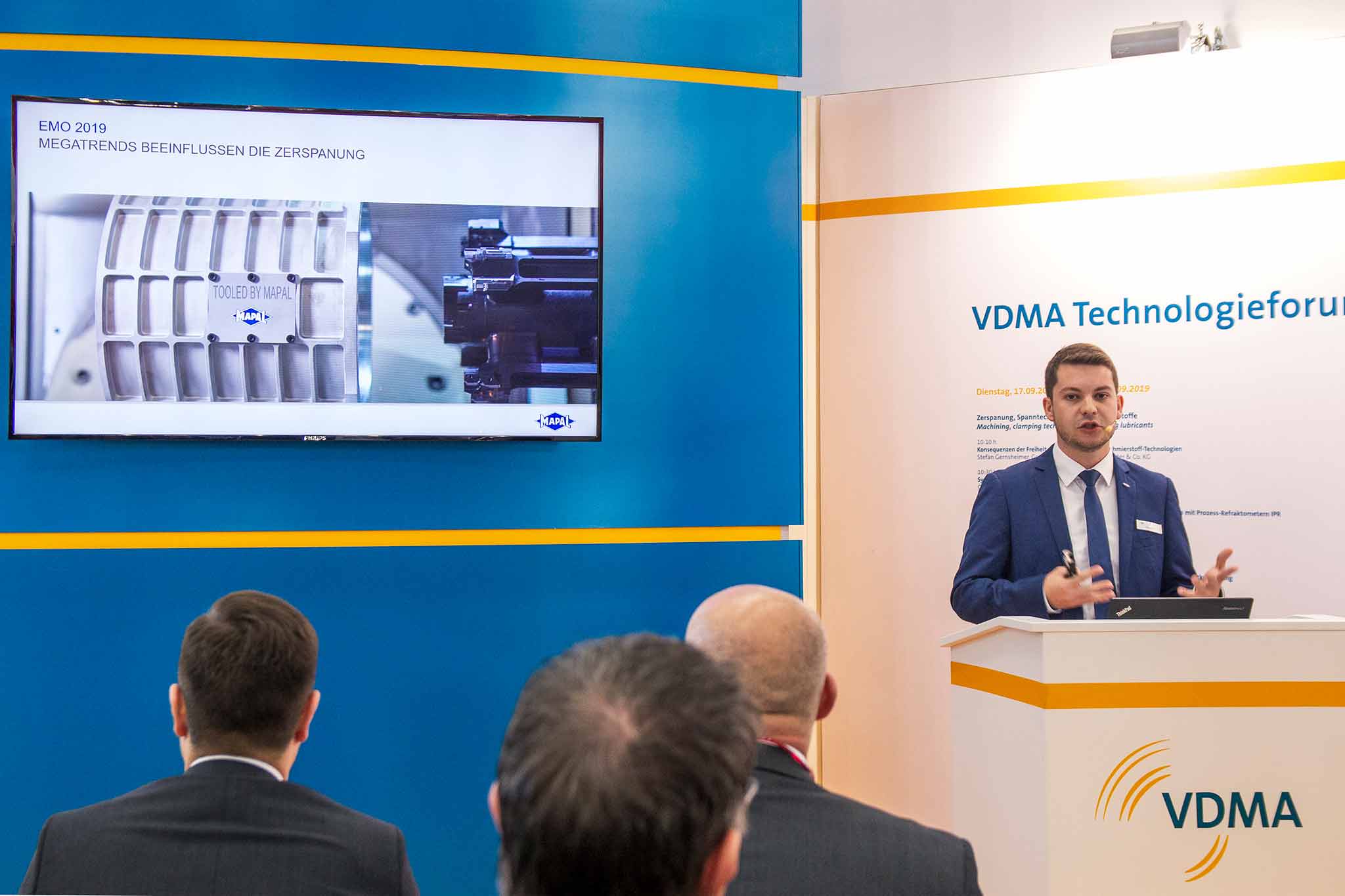 Dennis Minder speaks at the VDMA Technology Forum. He is pictured on the right side of the image, his presentation is shown in large on the left.
