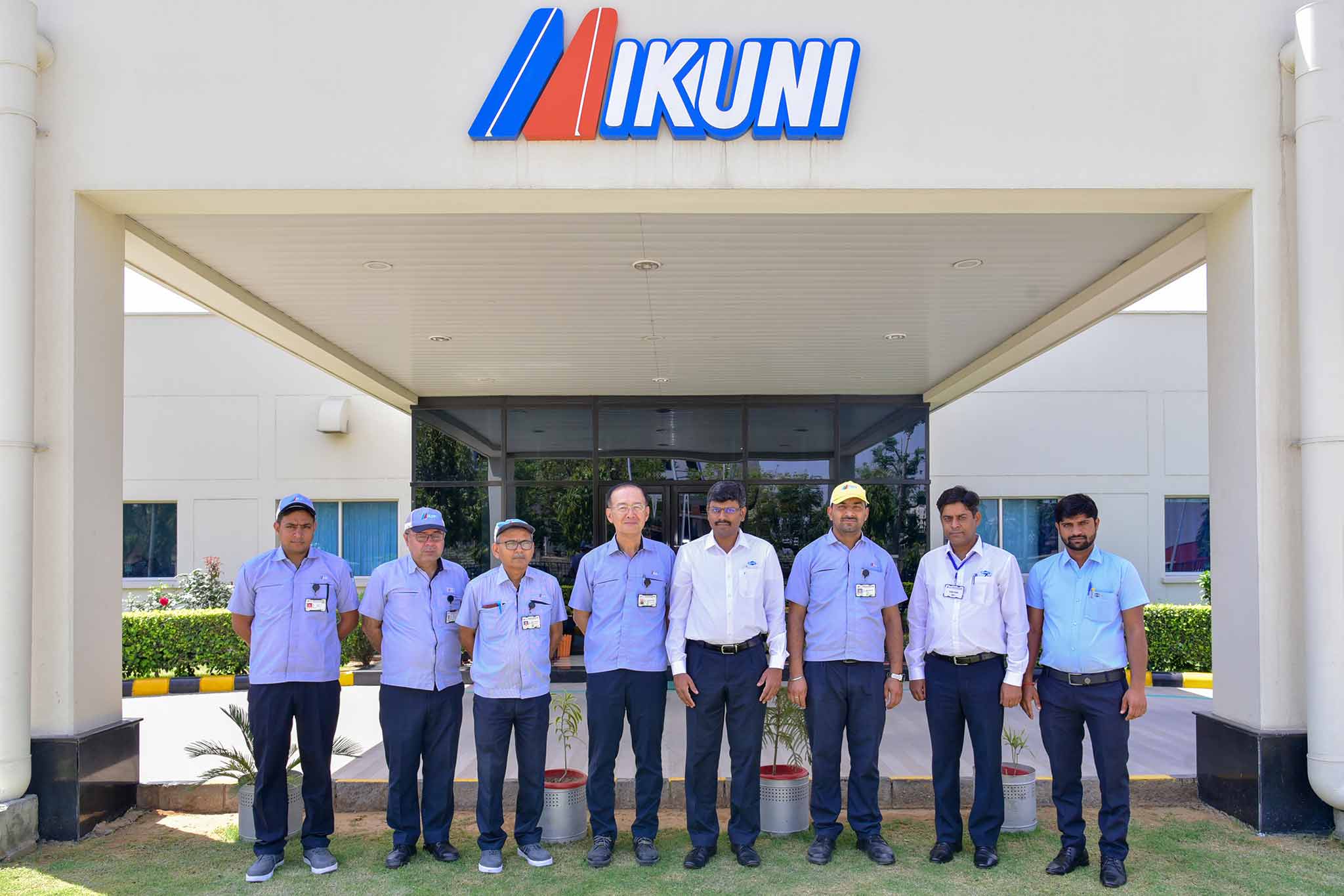 The teams from Mikunu and MAPAL, a total of eight people, stand in front of the Mikuni India building.