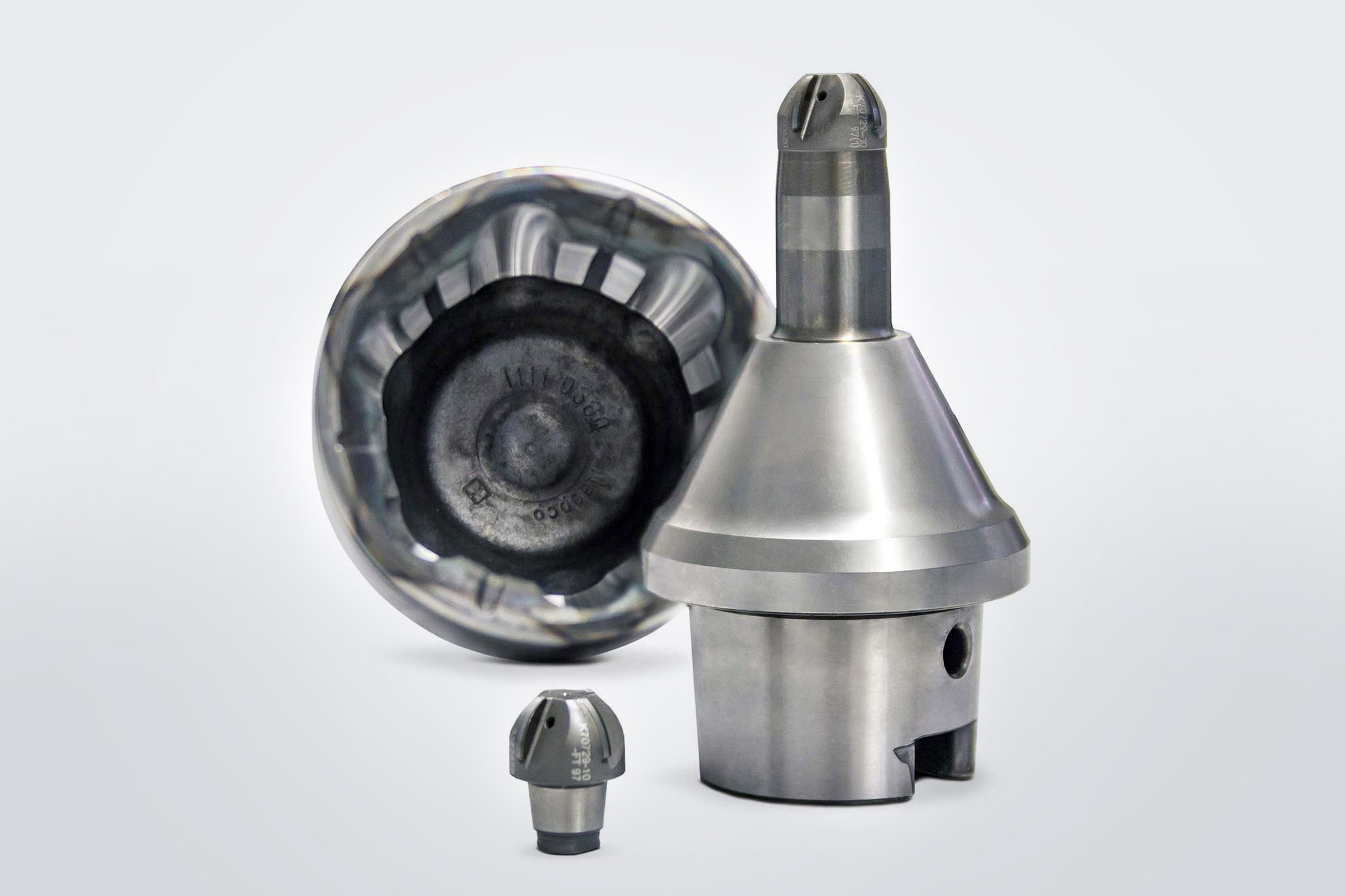 One ball cutter head and one ball nose milling cutter with tool holder and connection. The spherical shell is in the background. 